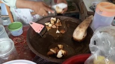 Cingur salatası havan topuzuyla baharatları karıştırıyor. Sokak yemekleri standı