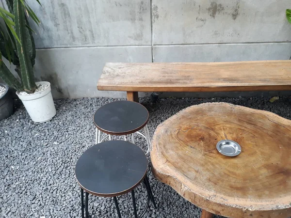a caf table and chairs with stone floors and plant decorations on the walls