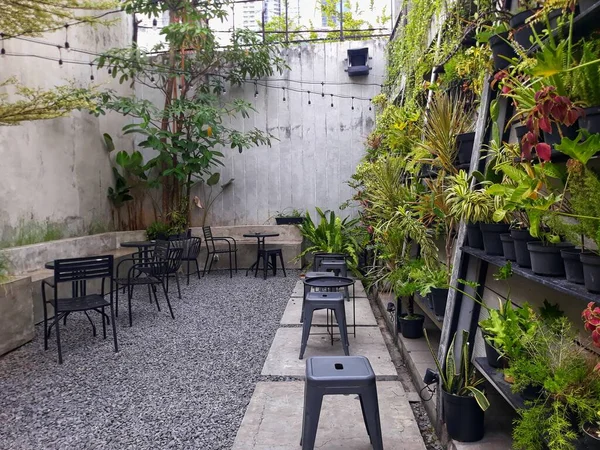 a caf table and chairs with stone floors and plant decorations on the walls