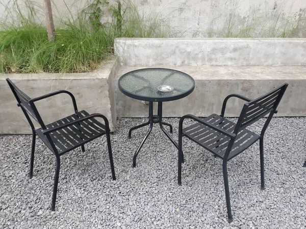 a caf table and chairs with stone floors and plant decorations on the walls