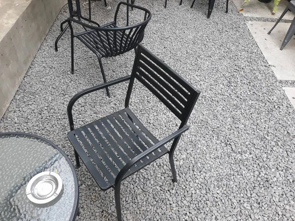 a caf table and chairs with stone floors and plant decorations on the walls