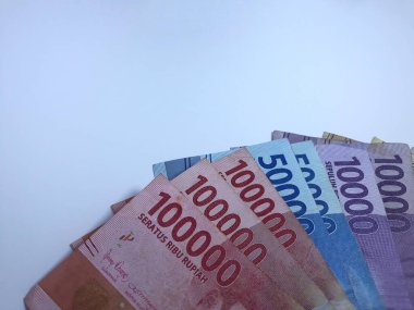 Rupiah 'a ait birkaç banknot tutan beyaz eli kapalı yakın çekim. Rupiah Endonezya 'nın para birimidir.