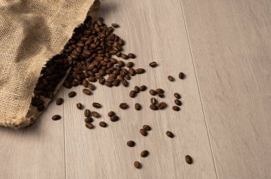 Fotokopi alanı olan bir çuvala dökülen kahve çekirdekleri.