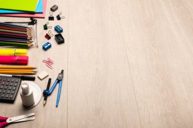 Back to school supplies, school stationary items on a light wood background with copy space