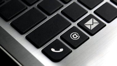 Laptop klavye tuşundaki telefon, e-posta ve posta simgesi. Bizimle iletişime geçmek için kavram.