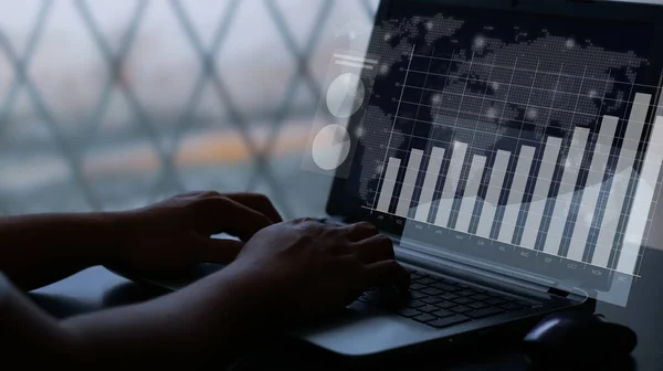 User typing on a laptop with virtual screen of performance graph dashboard. Concept for financial, business, progress performance and dashboard.