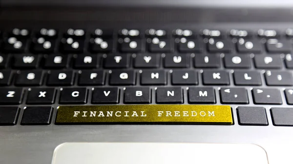 FINANCIAL FREEDOM word on laptop keyboard button. Concept business and financial