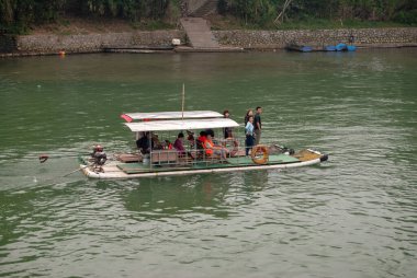 Guilin, Çin - 4 Mayıs 2010: Yerel halk bambu motorlu bir tekneyle Li Nehri boyunca seyahat ediyor