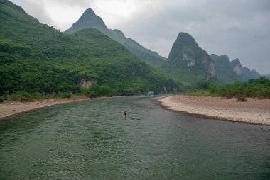 Guilin, Çin - 4 Mayıs 2010: Yerel tüccarlar bambu teknesiyle Li nehrinde yüzüyorlar