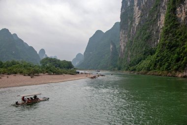 Guilin, Çin - 4 Mayıs 2010: Yerel halk bambu motorlu bir tekneyle Li Nehri boyunca seyahat ediyor