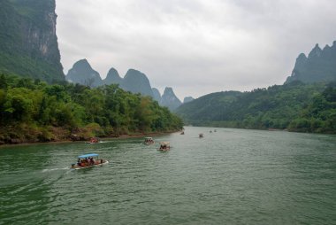 Guilin, Çin - 4 Mayıs 2010: Yerel halk bambu motorlu bir tekneyle Li Nehri boyunca seyahat ediyor