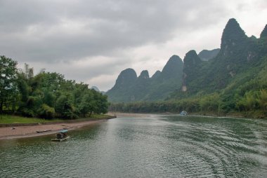 Guilin, Çin - 4 Mayıs 2010: Yerel halk bambu motorlu bir tekneyle Li Nehri boyunca seyahat ediyor
