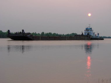 Omsk, Rusya - 12 Ağustos 2010: Güneşin arka planına karşı İrlanda Nehri 'nde bir mavnası olan Pusher