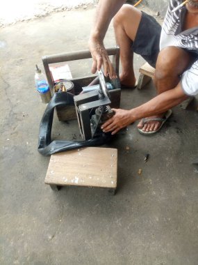 Tamirci atölyesinde motosiklet lastiklerini tamir ediyor..