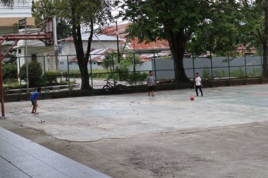Gorontalo-Indonesia, June 2022 - Children practicing soccer on a basketball court during the day