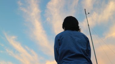 silhouette of a person standing on a bridge enjoying the sunrise