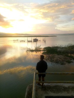 Silhouette of a man fishing in the afternoon. sunset on lake Limboto, Indonesia