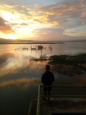 Silhouette of a man fishing in the afternoon. sunset on lake Limboto, Indonesia