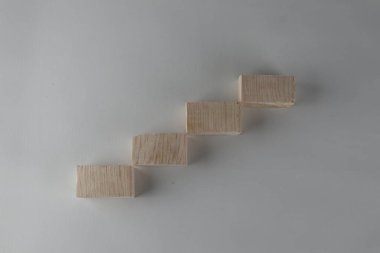 Ahşap blok merdiven gibi dizilmiş. Büyüme süreci için iş konsepti.