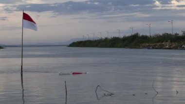 Göl kenarında dalgalanan Endonezya bayrağı. Endonezya bayrağı 17 Ağustos 'ta Endonezya' nın bağımsızlık gününde göndere çekildi