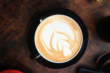 Coffee in black cup on old grunge dark textured wooden background