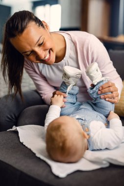 Young happy mother and her baby playing while spending time together at home. 