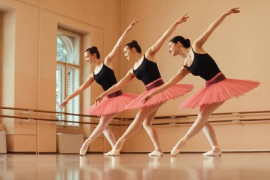 Low angle view of female ballet dancers practicing choreography at dance studio. 