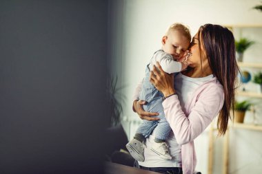 Young mother enjoying with her baby at home. Copy space. 