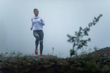 Young sportswoman feeling determined for workout and running in misty weather. Copy space. 