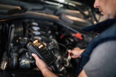 Close-up of auto mechanic doing car diagnostic at service workshop. 