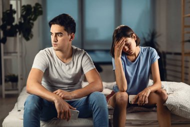 Young couple feeling displeased  because relationship problems they have among each other. 