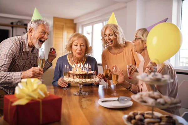 Group Cheerful Seniors Having Fun Birthday Party While Woman Blowing — стоковое фото