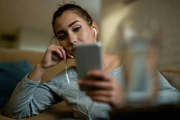 Молодая Недовольная Женщина Пользуется Мобильным Телефоном Читает Смс Вечером Дома — стоковое фото