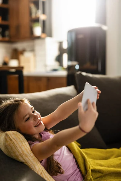 Happy Little Girl Using Mobile Phone Taking Selfie Sofa Living — Stockfoto