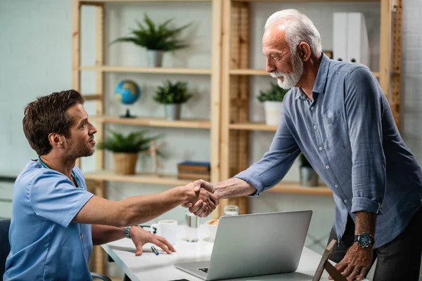 Male Doctor Shaking Hands Senior Patients Who Came Medical Appointment — Fotografia de Stock