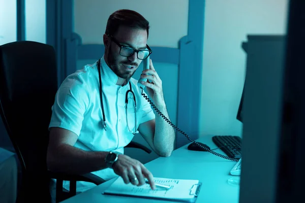 Mid Adult Doctor Talking Patient Phone While Analyzng Medical Reports — Foto de Stock