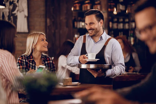 Young Happy Waiter Serving Coffee While Talking Female Guest Cafe — Stockfoto