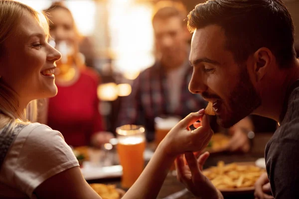 Young Couple Enjoying Lunch Friends Restaurant Young Man Being Fed — Foto de Stock