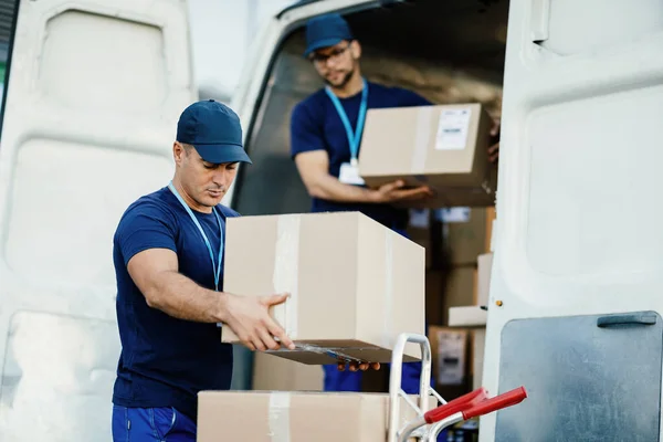 Young Courier His Colleague Unloading Cardboard Boxes Delivery Van — Foto Stock