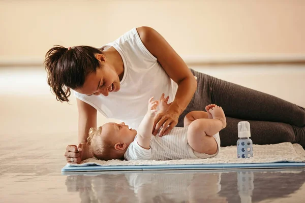 Happy Athletic Mother Playing Her Baby Boy Who Lying Exercise — Foto de Stock