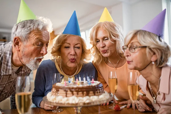 Счастливые Зрелые Люди Задувают Свечи Торте Веселятся Домашней Вечеринке — стоковое фото