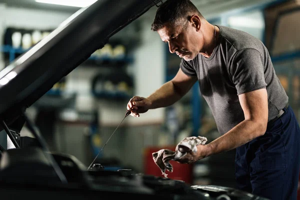 Mid Adult Mechanic Examining Car Oil Auto Repair Shop —  Fotos de Stock