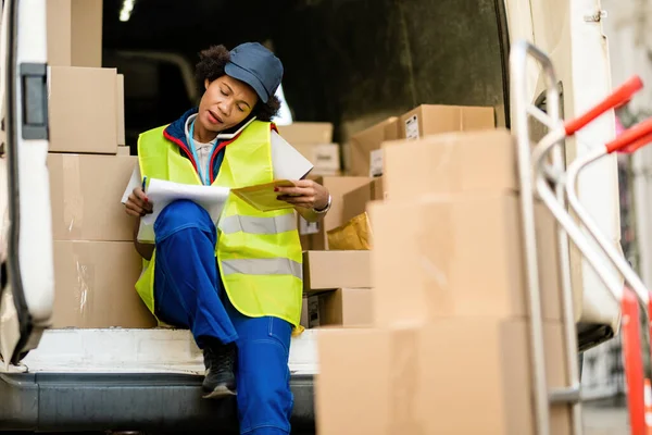 African American Delivery Woman Talking Phone While Going Delivery List — Foto Stock