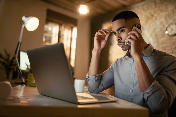 Serious African American Businessman Making Phone Call While Working Laptop — Stock Fotó