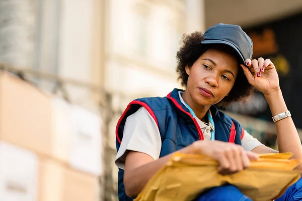 Black Female Courier Taking Break While Feeling Tired Delivering Packages — Stok fotoğraf