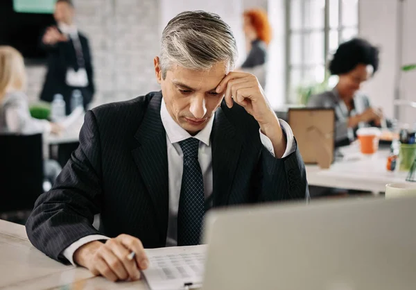Mid Adult Businessman Thinking While Reading Business Reports Office Desk — Foto de Stock