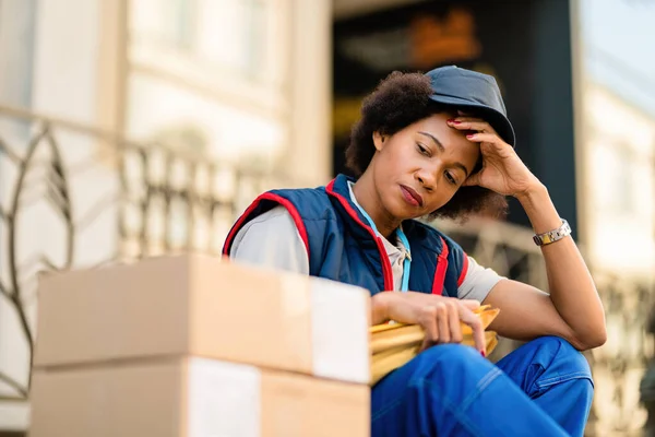 Tired African American Delivery Woman Resting Next Packages Street — Stok fotoğraf