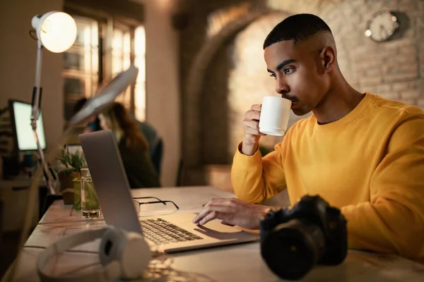 Young Black Businessman Drinking Coffee While Working Late Computer Office — Stock Fotó