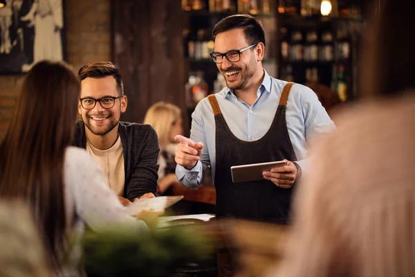 Happy Waiter Using Digital Tablet Talking Guests While Taking Order — Foto de Stock