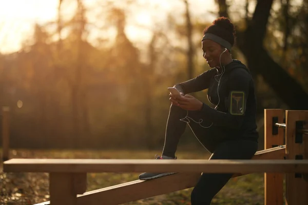 Happy African American Sportswoman Using Smart Phone While Taking Break — Stock Fotó